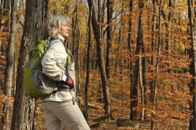 Woman hiking through woods with backpack