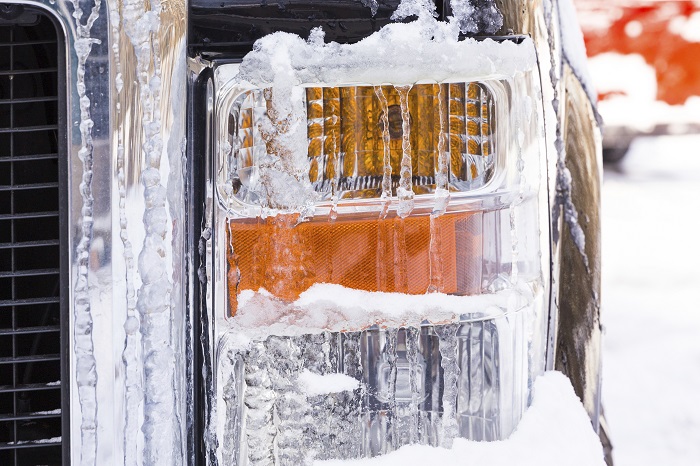An ice and snow covered car headlight.